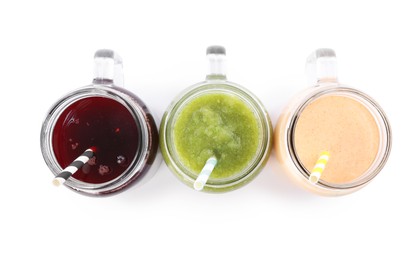 Photo of Superfood. Different tasty smoothies in mason jars isolated on white, top view