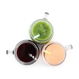 Photo of Superfood. Different tasty smoothies in mason jars isolated on white, top view
