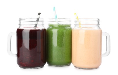 Photo of Superfood. Different tasty smoothies in mason jars isolated on white