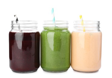 Photo of Superfood. Different tasty smoothies in mason jars isolated on white