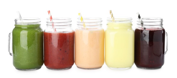 Photo of Superfood. Different tasty smoothies in mason jars isolated on white