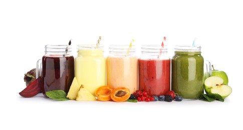 Photo of Superfood. Different tasty smoothies in mason jars and ingredients isolated on white