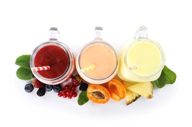 Photo of Superfood. Different tasty smoothies in mason jars and ingredients isolated on white, top view