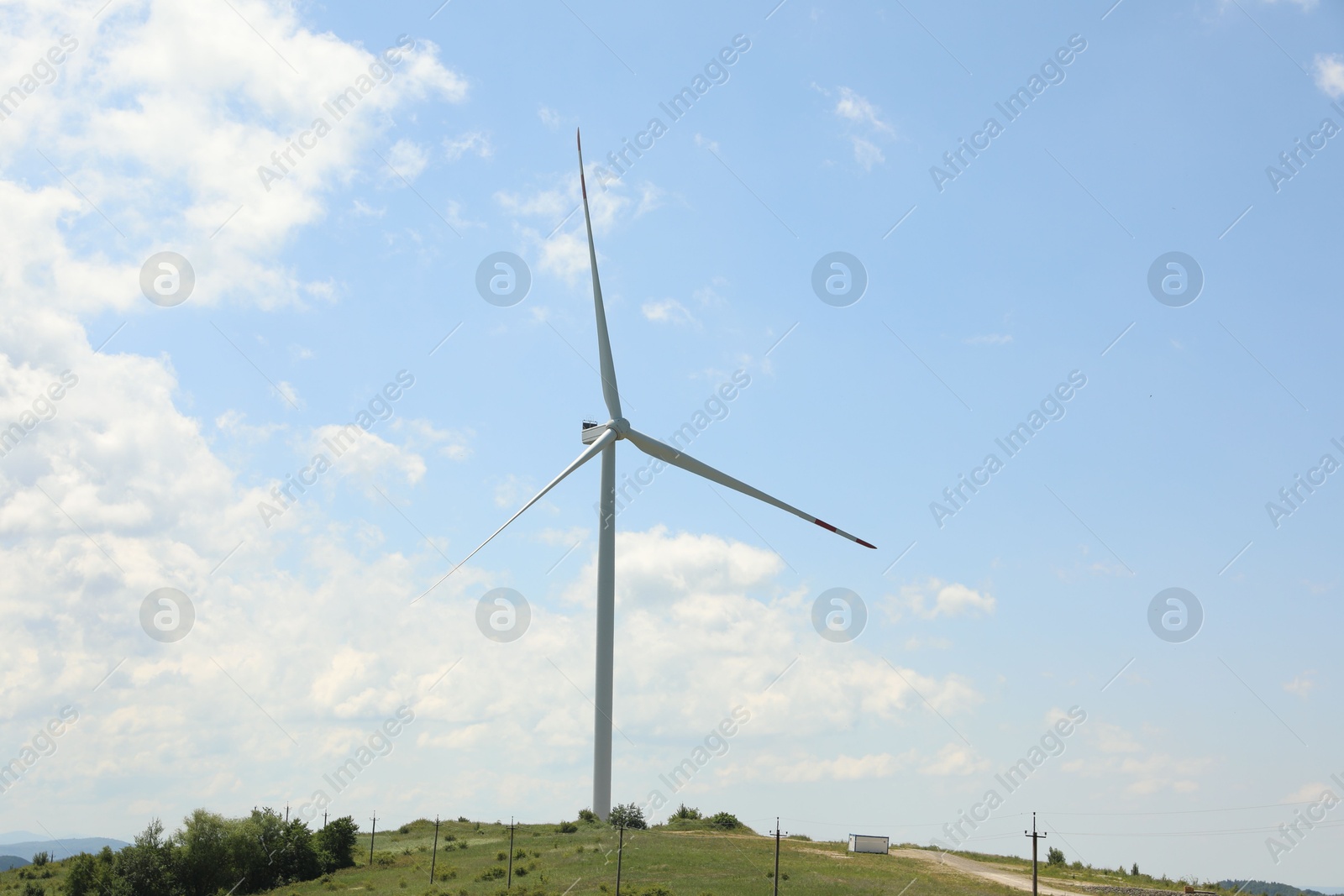 Modern wind turbine in field on sunny day Photo of Modern wind turbine in field on sunny day