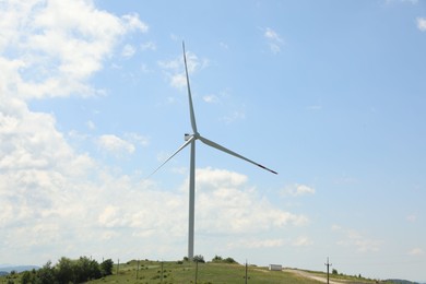 Photo of Modern wind turbine in field on sunny day