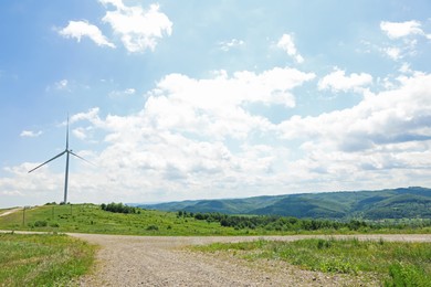 Photo of Modern wind turbine in field on sunny day