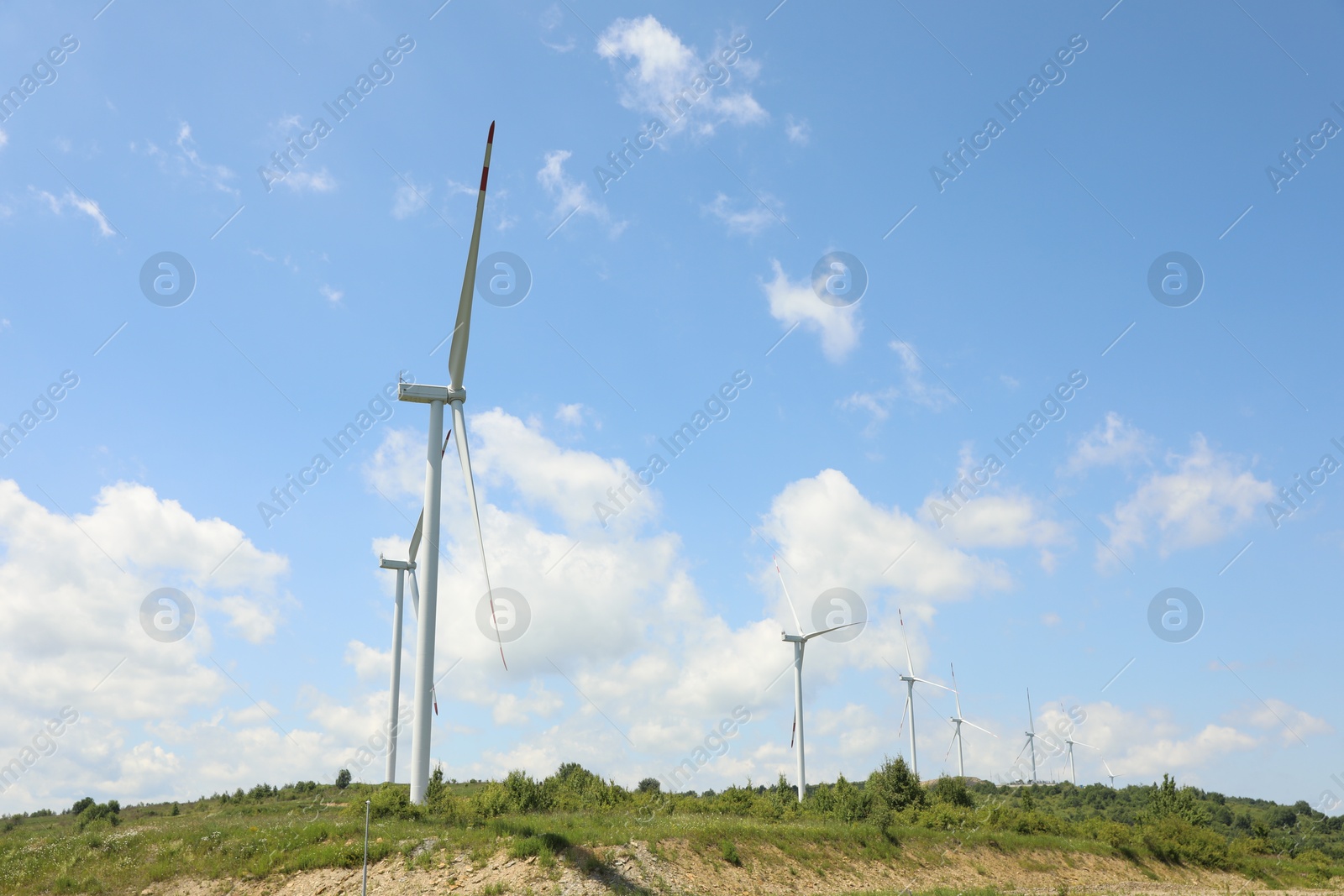 Modern wind turbines in field on sunny day Photo of Modern wind turbines in field on sunny day