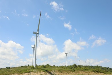 Photo of Modern wind turbines in field on sunny day