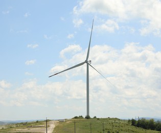 Photo of Modern wind turbine in field on sunny day