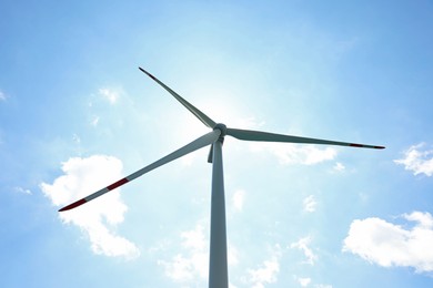 Photo of Modern wind turbine against blue sky, low angle view
