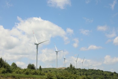 Photo of Modern wind turbines in field on sunny day