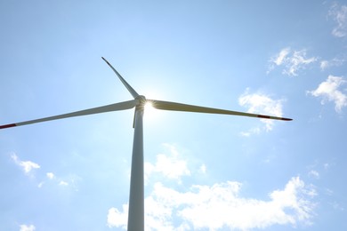Photo of Modern wind turbine against blue sky, low angle view