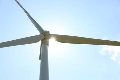 Photo of Modern wind turbine against blue sky, low angle view