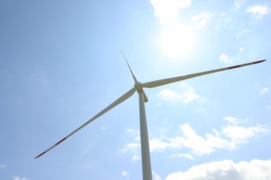 Photo of Modern wind turbine against blue sky, low angle view