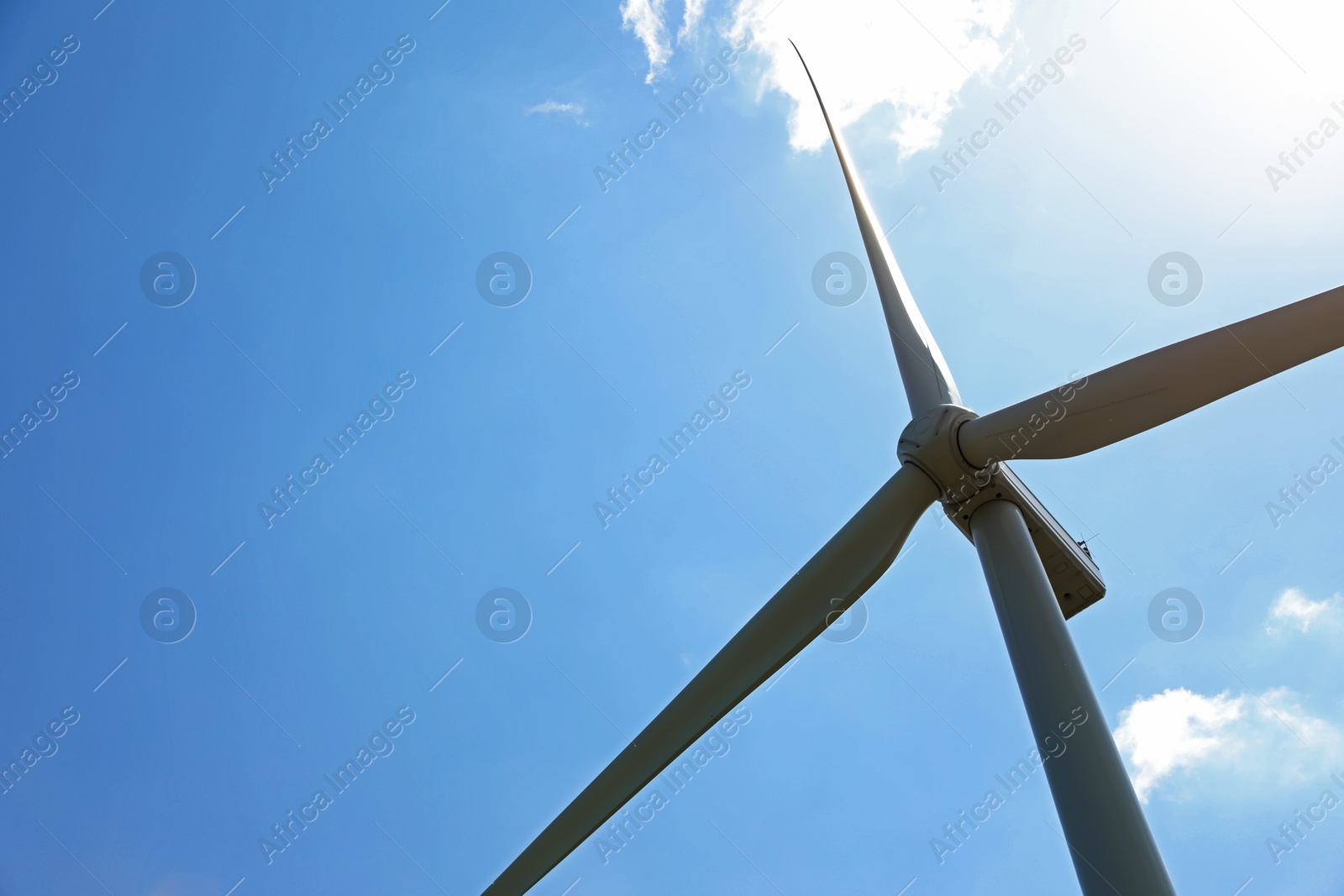 Modern wind turbine against blue sky, low angle view. Space for text Photo of Modern wind turbine against blue sky, low angle view. Space for text