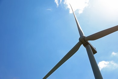 Photo of Modern wind turbine against blue sky, low angle view. Space for text