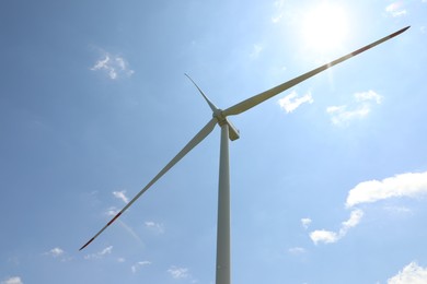 Photo of Modern wind turbine against blue sky, low angle view