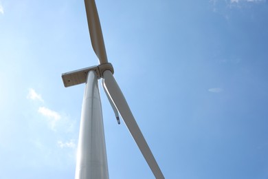 Photo of Modern wind turbine against blue sky, low angle view. Space for text