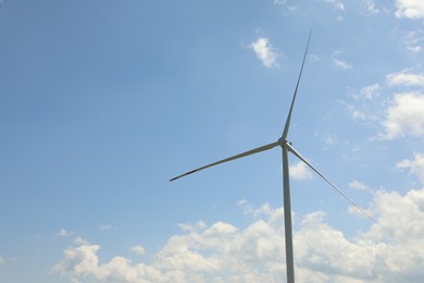 Photo of Modern wind turbine against blue sky, closeup