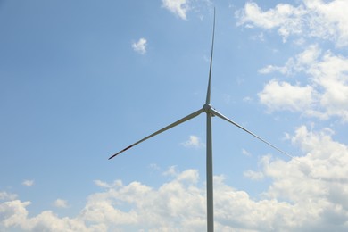 Photo of Modern wind turbine against blue sky, closeup