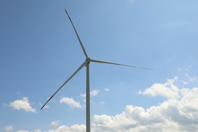 Photo of Modern wind turbine against blue sky, closeup