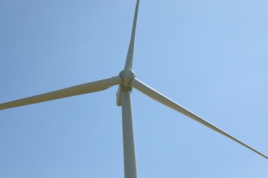Photo of Modern wind turbine against blue sky, closeup
