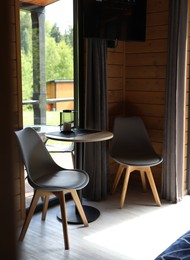 Photo of Table and chairs in stylish hotel room