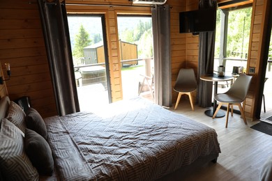 Photo of Comfortable bed and table with chairs in hotel room