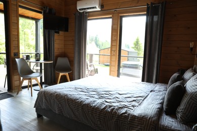 Photo of Comfortable bed and table with chairs in hotel room