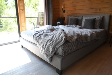 Photo of Comfortable bed near window in hotel room