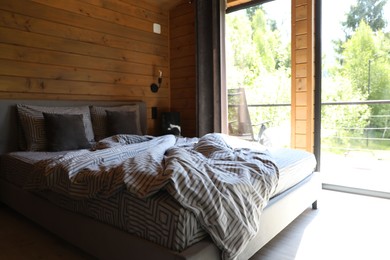 Photo of Comfortable bed near window in hotel room