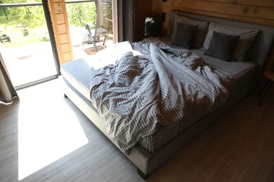 Photo of Comfortable bed near window in hotel room