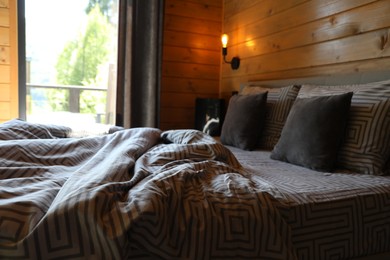 Photo of Comfortable bed near window in hotel room