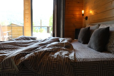 Photo of Comfortable bed near window in hotel room