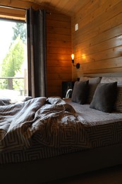 Photo of Comfortable bed near window in hotel room