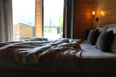 Photo of Comfortable bed near window in hotel room