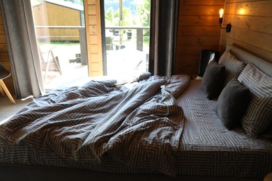 Photo of Comfortable bed near window in hotel room