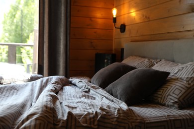 Photo of Comfortable bed near window in hotel room