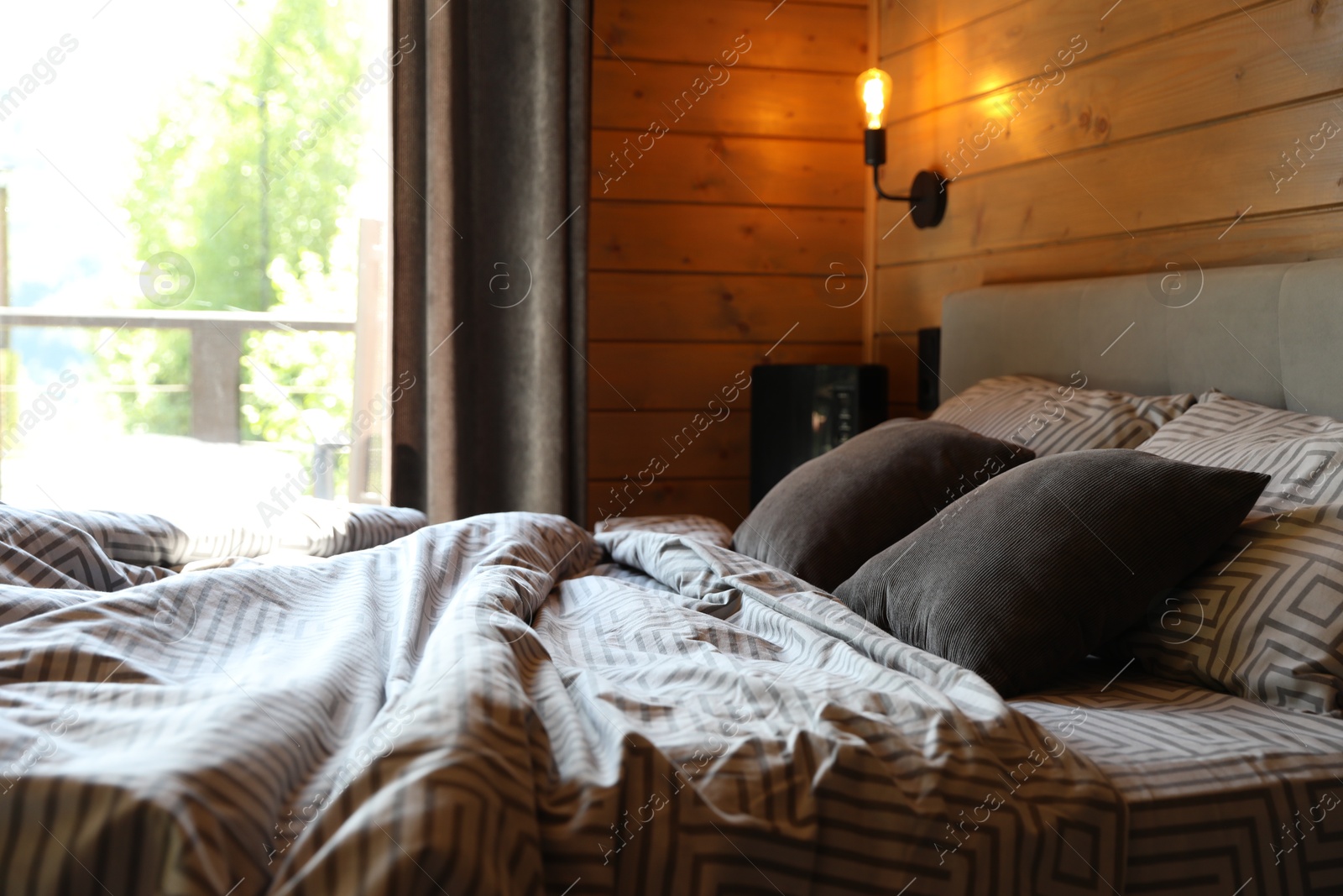 Photo of Comfortable bed near window in hotel room
