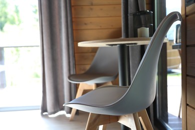 Photo of Table and chairs in stylish hotel room. Space for text