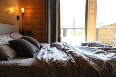 Photo of Comfortable bed near window in hotel room