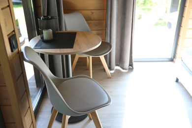 Photo of Table and chairs in stylish hotel room. Space for text