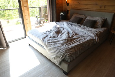 Photo of Comfortable bed near window in hotel room