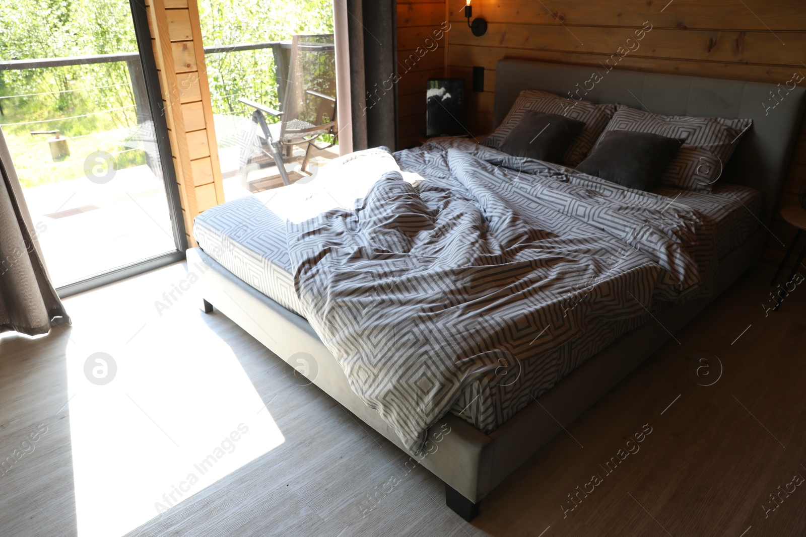 Photo of Comfortable bed near window in hotel room