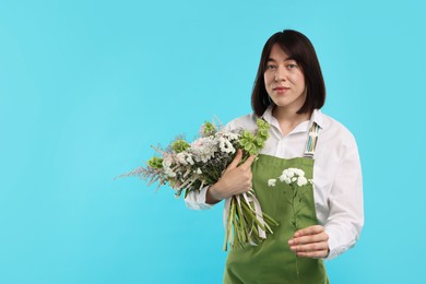 Photo of Florist with beautiful bouquet of flowers on light blue background, space for text