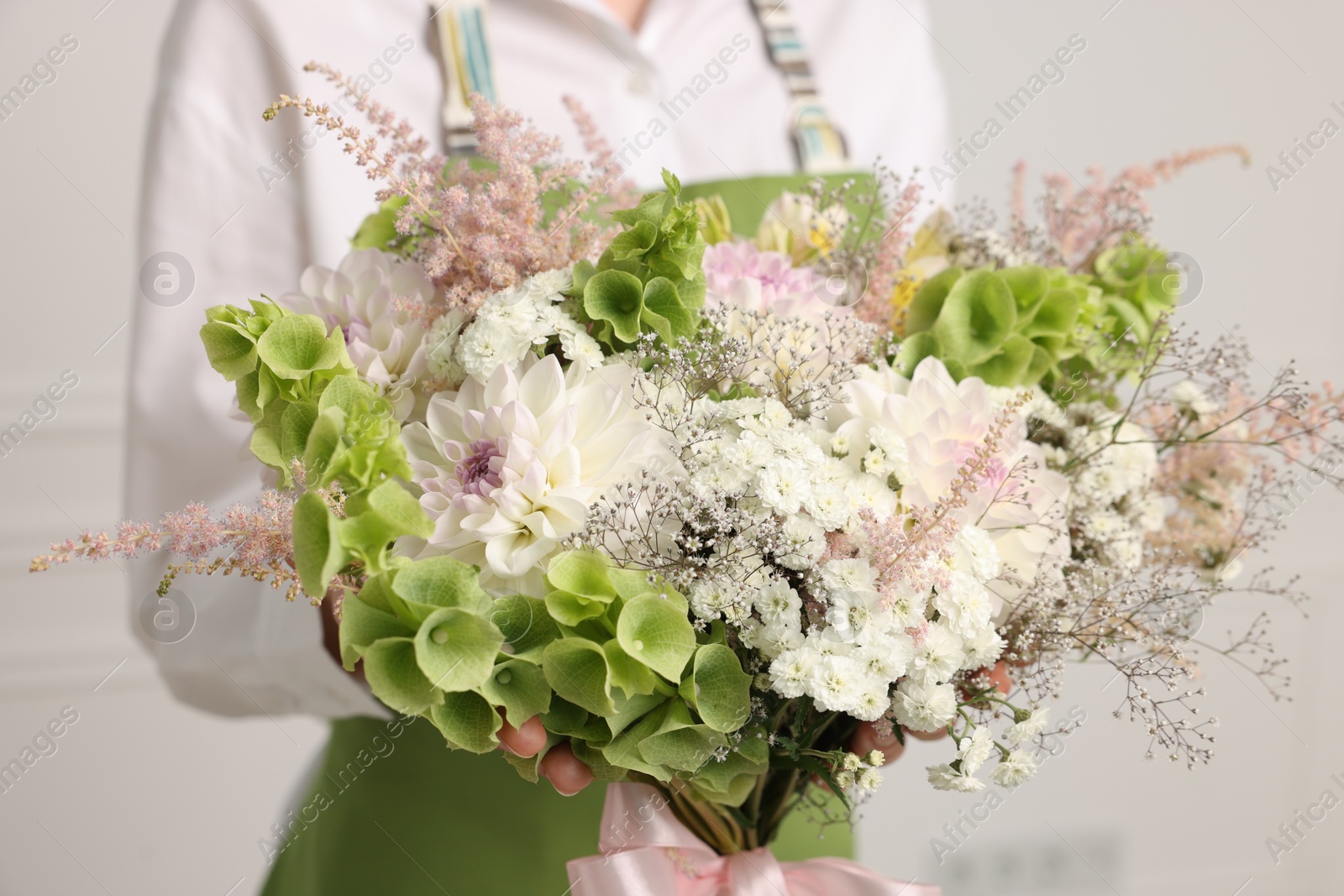 Florist with beautiful bouquet of flowers indoors, closeup Photo of Florist with beautiful bouquet of flowers indoors, closeup