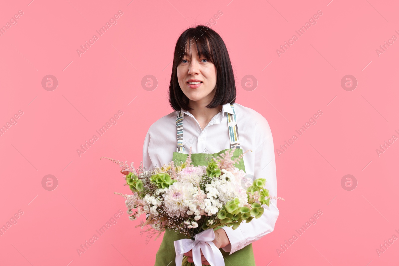 Photo of Florist with beautiful bouquet of flowers on pink background