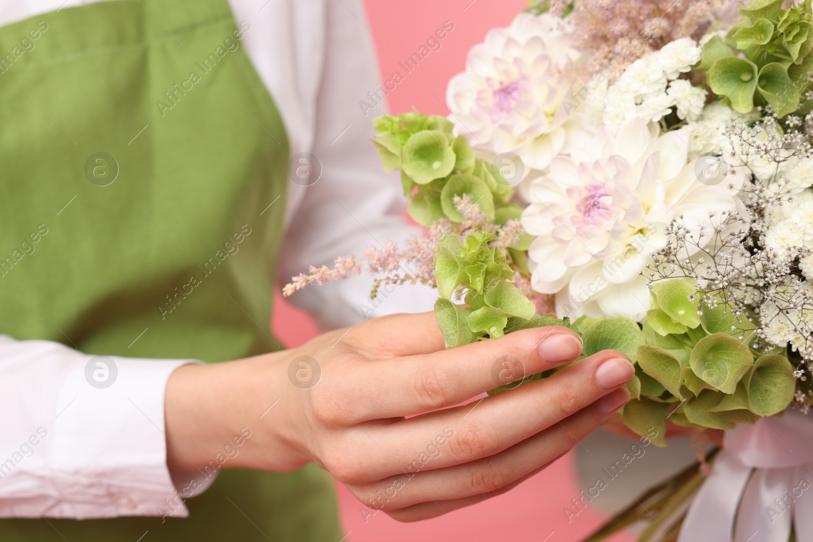 Florist with beautiful bouquet of flowers on pink background, closeup Photo of Florist with beautiful bouquet of flowers on pink background, closeup