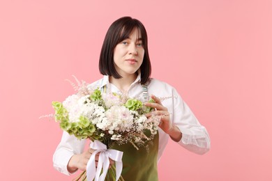 Photo of Florist with beautiful bouquet of flowers on pink background