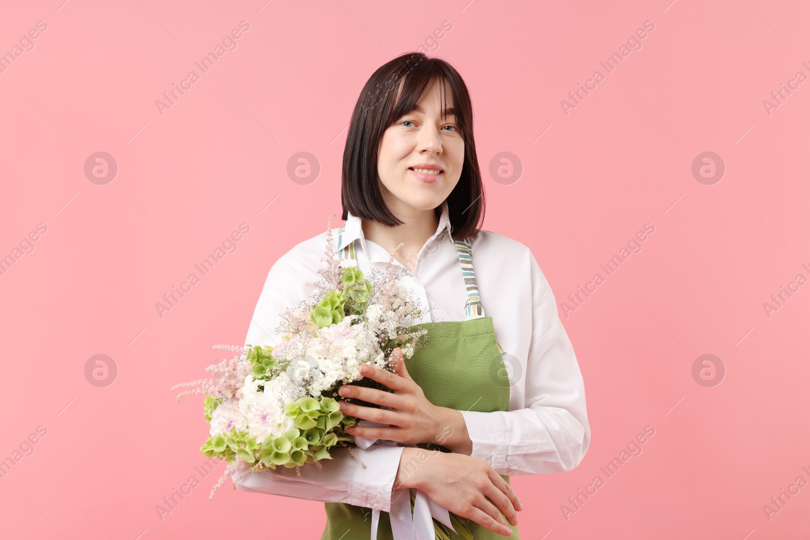 Florist with beautiful bouquet of flowers on pink background Photo of Florist with beautiful bouquet of flowers on pink background